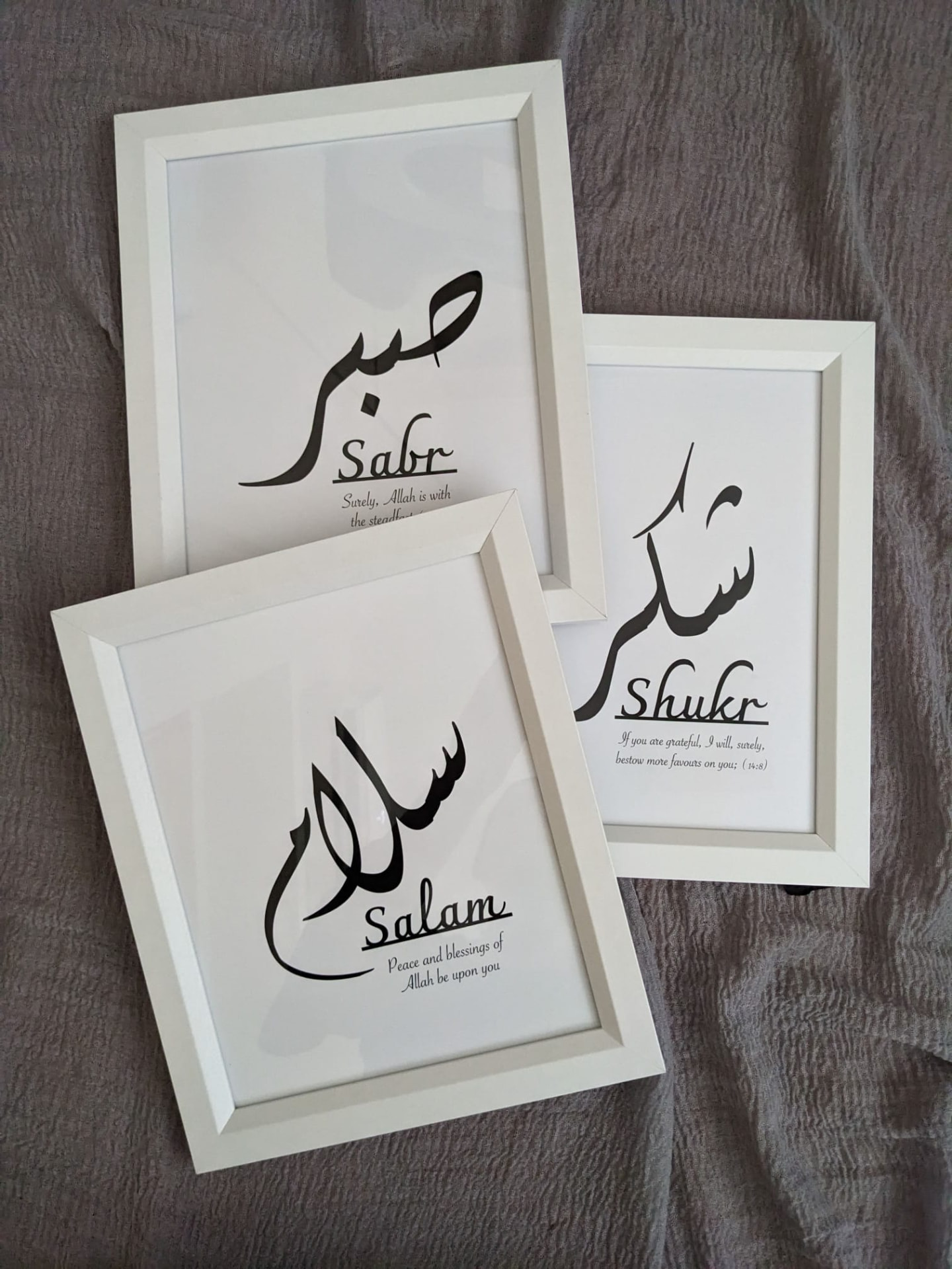 Three white frames reading Sabr, Shukr and Salam in brush calligraphy with short translations