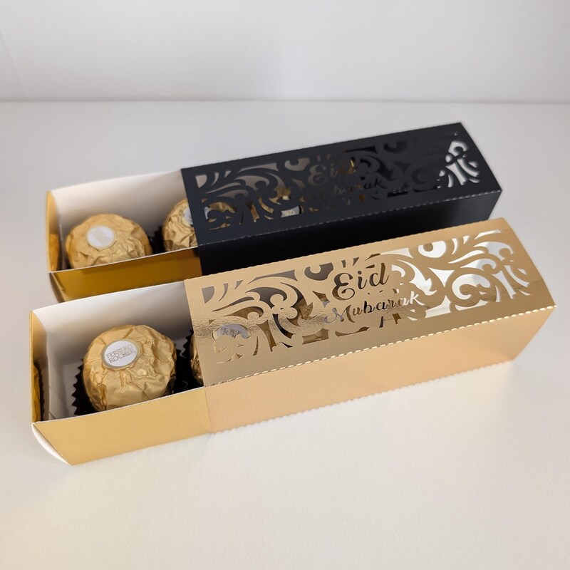 Gold and black laser-cut Eid favour sleeves with chocolates inside